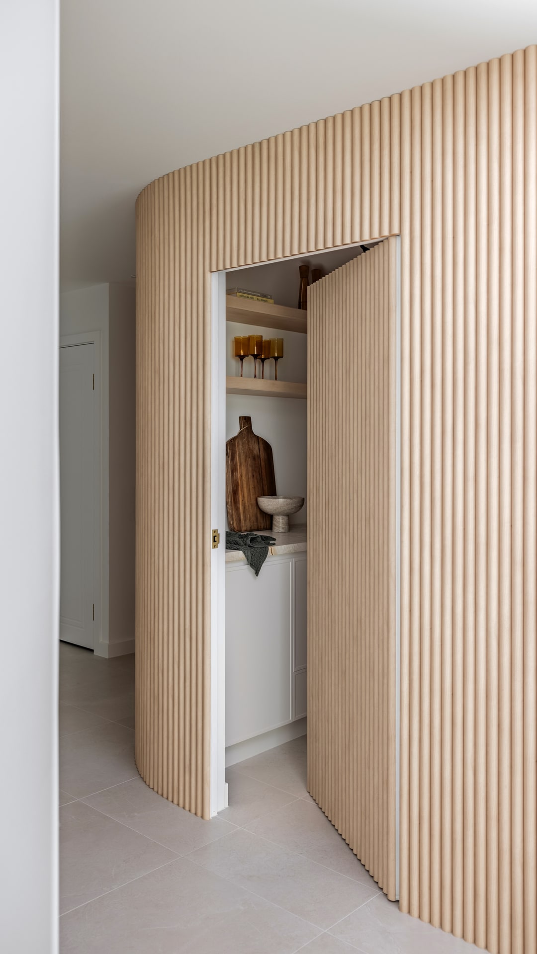The finished curved fluted wall with its concealed pantry door open, Broadbeach