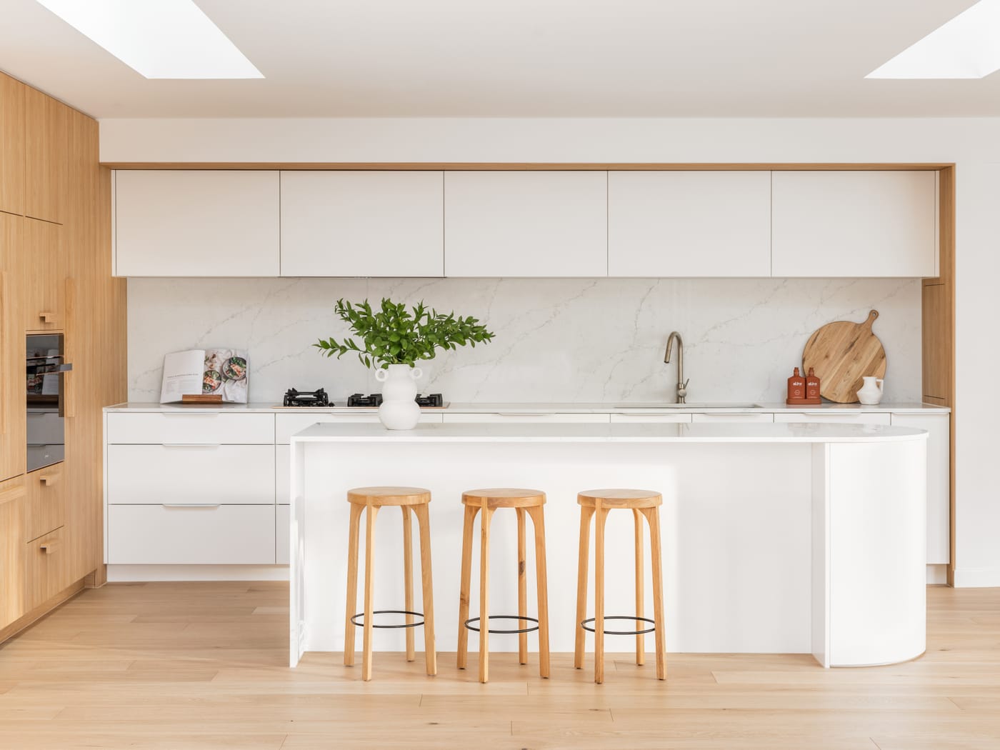 White and oak kitchen with a curved island in a Paradise Point renovation - 4D Cabinetry